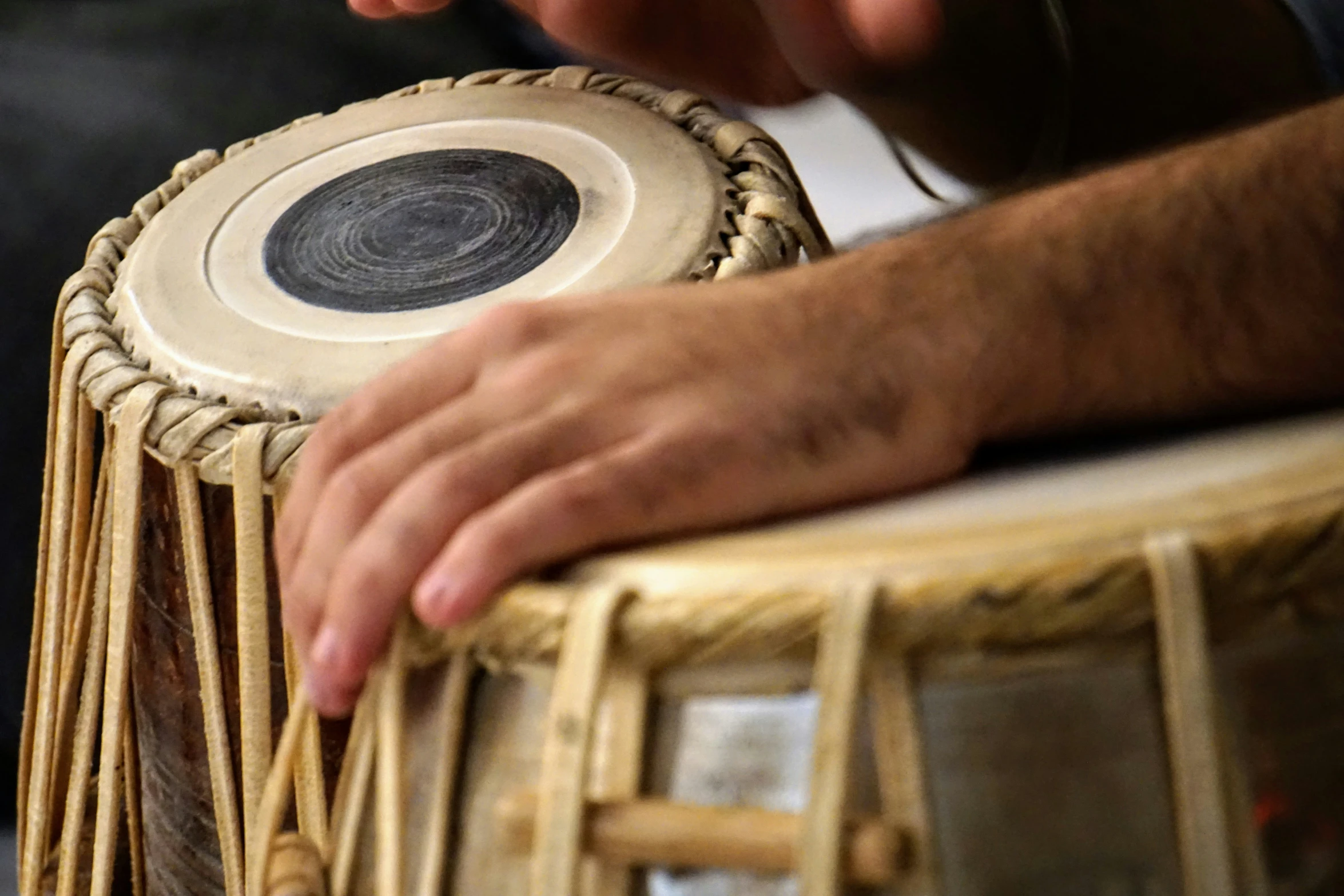 a man's hands are resting on top of a wooden tabla