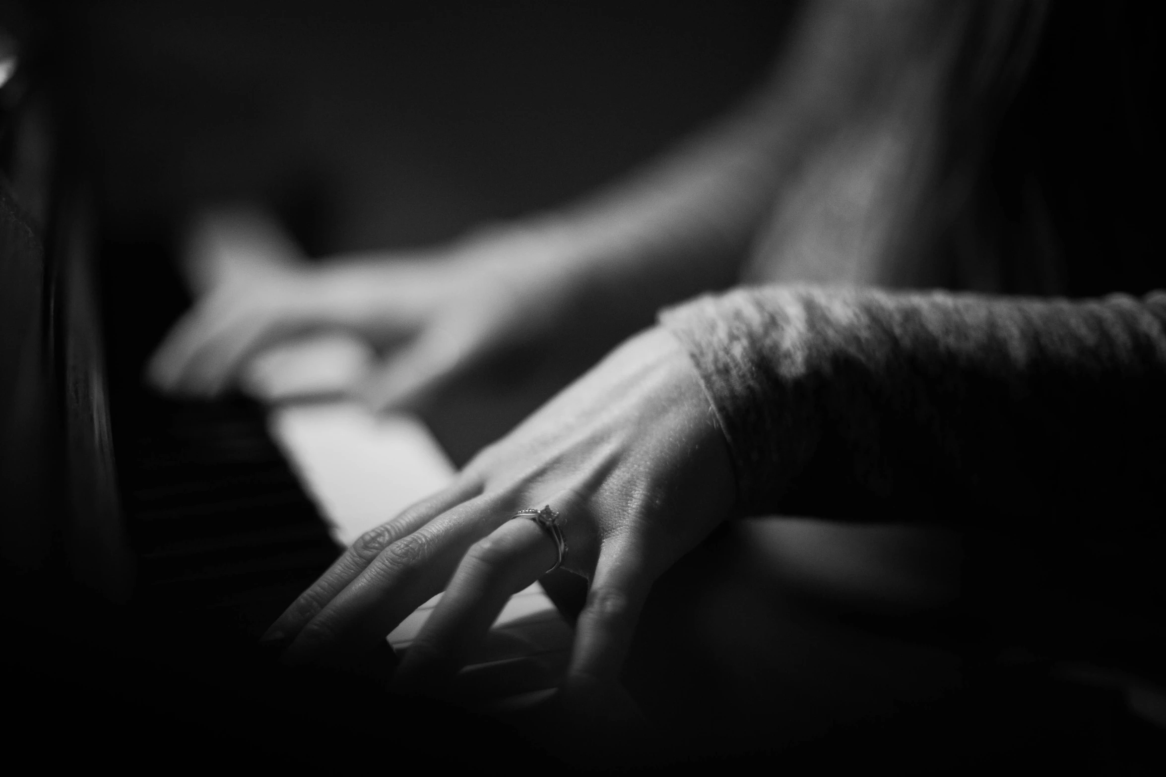 a person with their hands on top of the keys of a piano