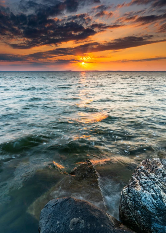 water that has some rocks in it and the sky in the background