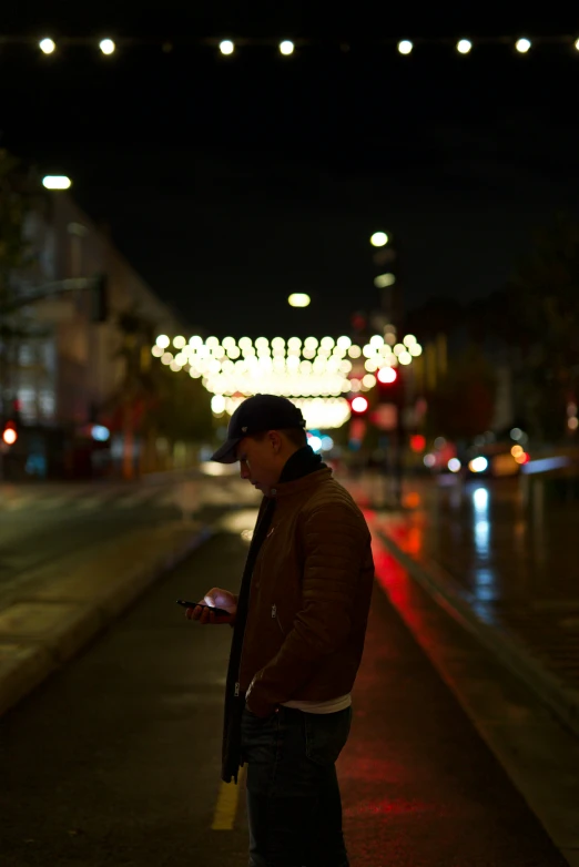 a man standing outside at night using his phone