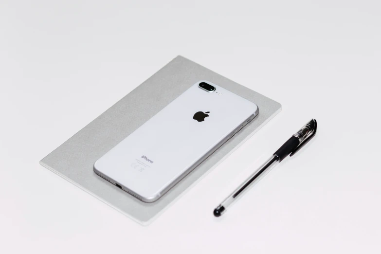 an iphone sits in the case next to a small black pen