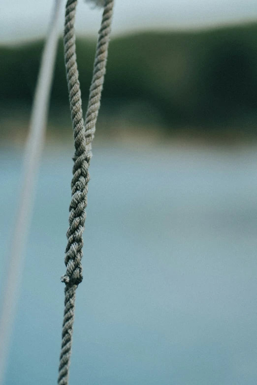 a close up of ropes with water in the background
