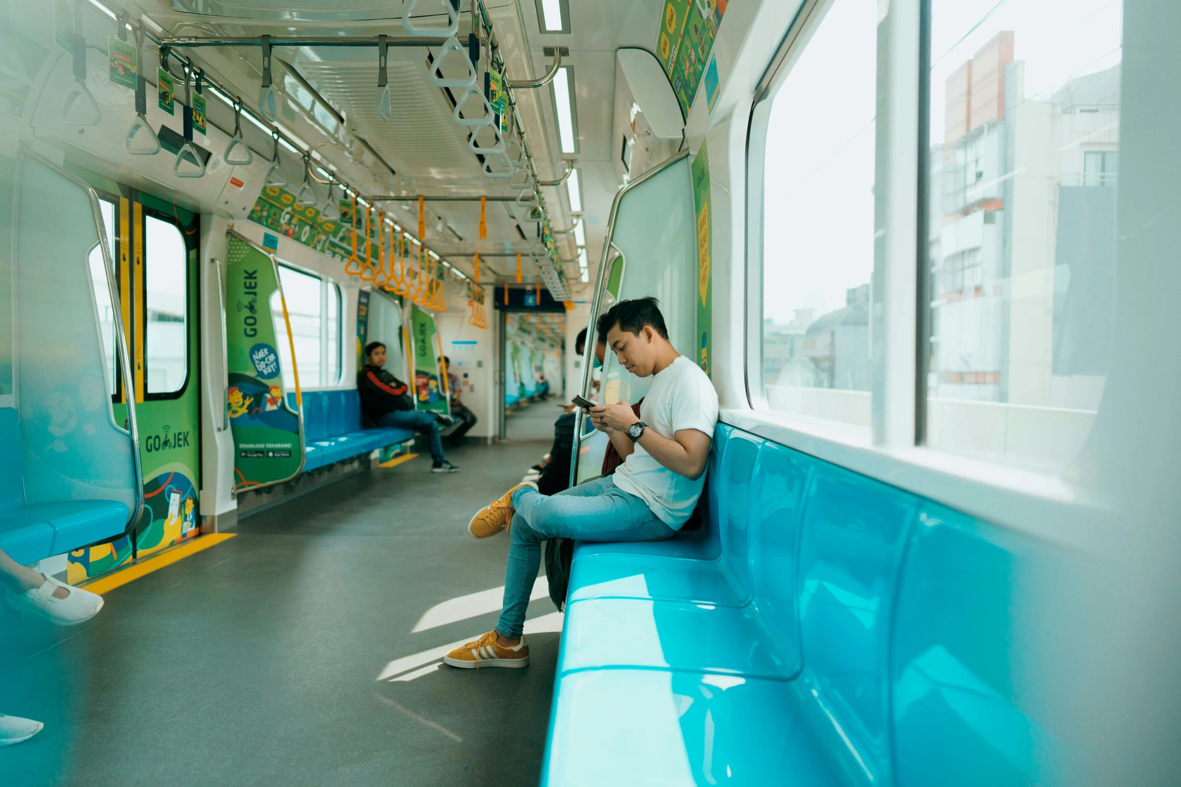 a man sitting on the seat in the subway reading a book