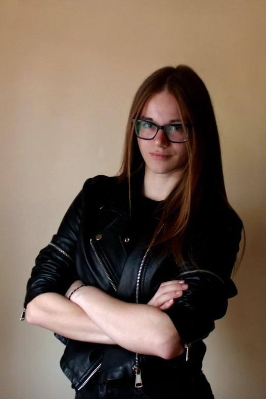 a woman in black jacket and glasses posing for the camera