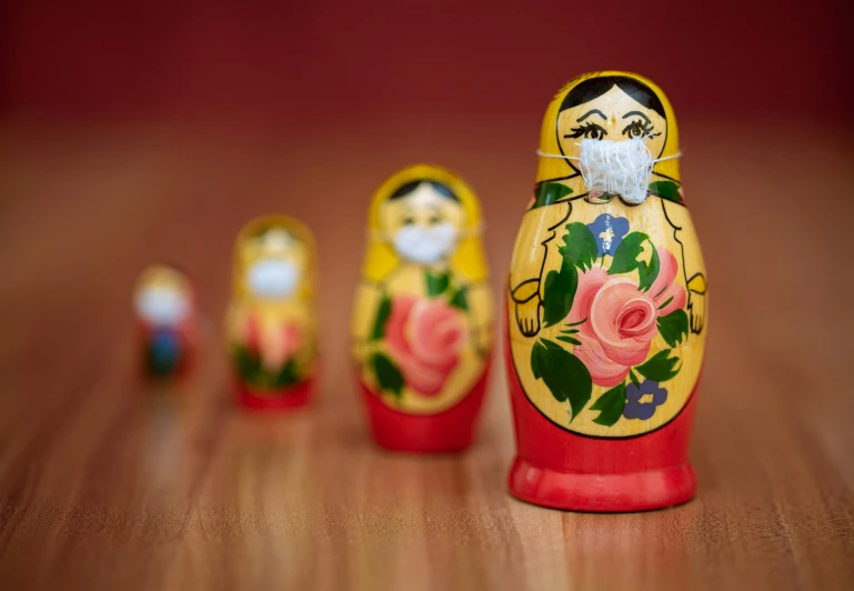 a wooden mat mat with three colorful mat doll and red one