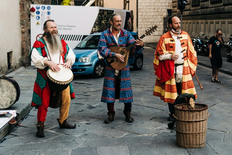 three men standing in the street playing instruments