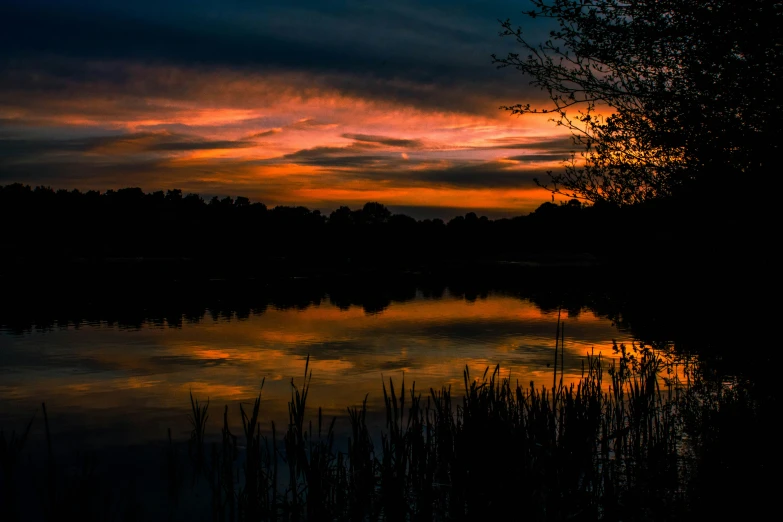 an image of a sunset with clouds over the water