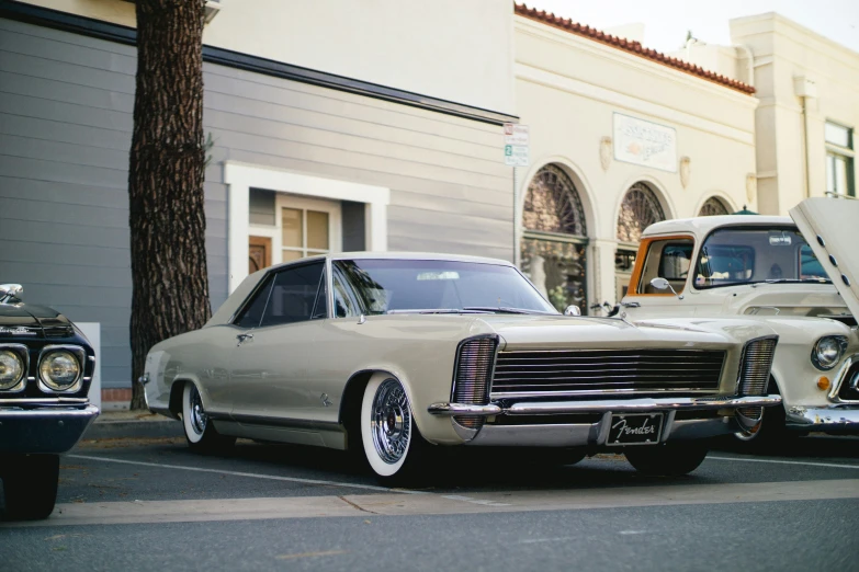 old cars parked in front of a building and tree