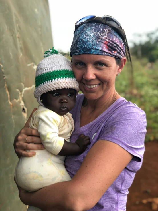 woman with baby in her arms wearing head band and hat