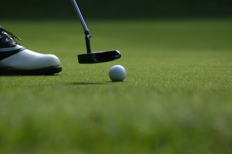 there is a golfer hitting the ball with his putter