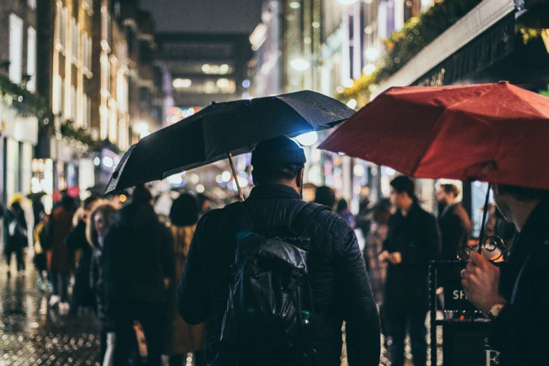 many people are walking with their umbrellas on the street