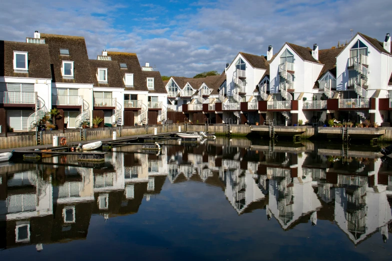 many white houses are along the water in front of a bridge