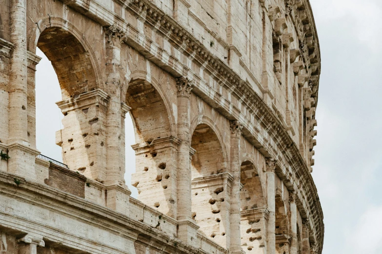 the roman structure has round pillars with intricate arches and carvings