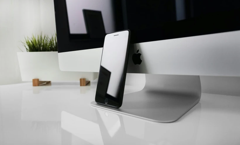 an iphone charging on top of a desk