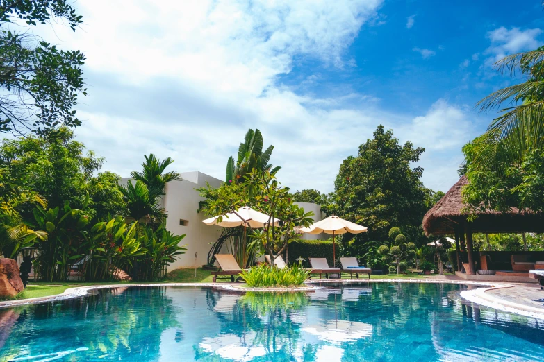 a pool and lounge chair with parasols in the back