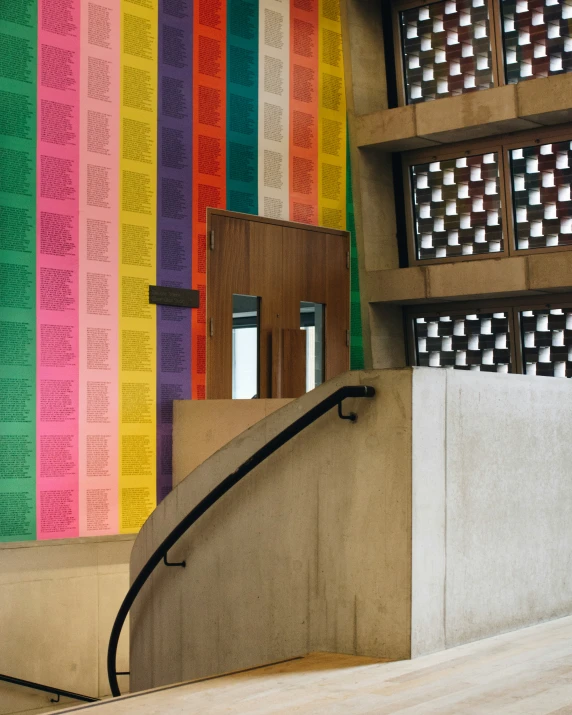 a stairway leading up to a building with many rainbow walls and bars in the background