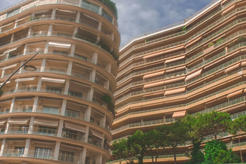 tall buildings made of balconies with cars passing them