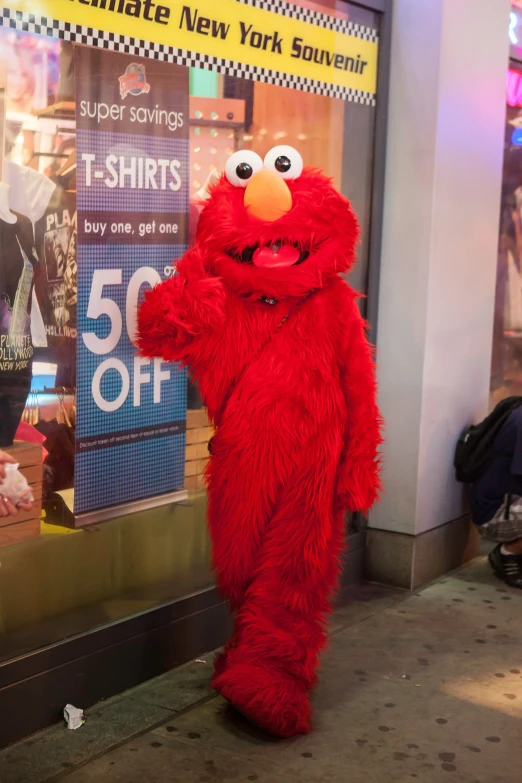 a man dressed in red with a fake face on walking