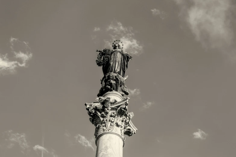 a very tall statue in front of the blue sky