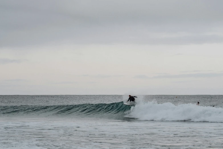 two surfers ride the top of the waves