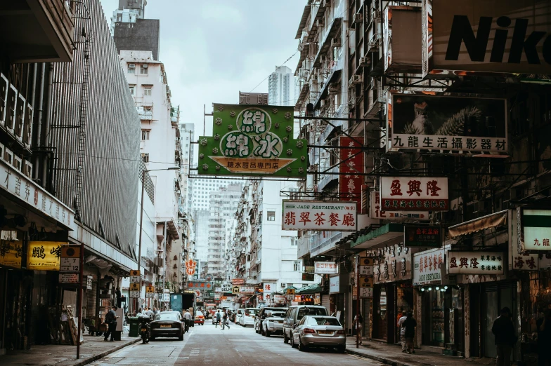 some people walk on a street with buildings and signs