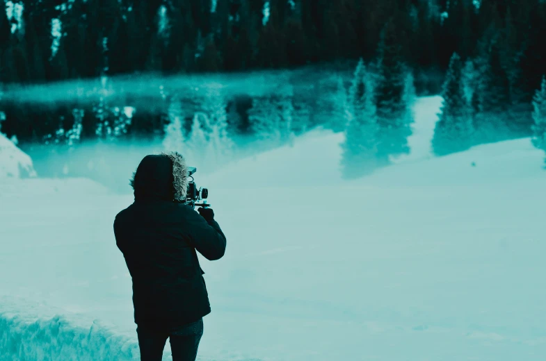 person standing in front of water with a camera