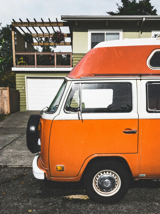 an orange and white van parked in front of a house