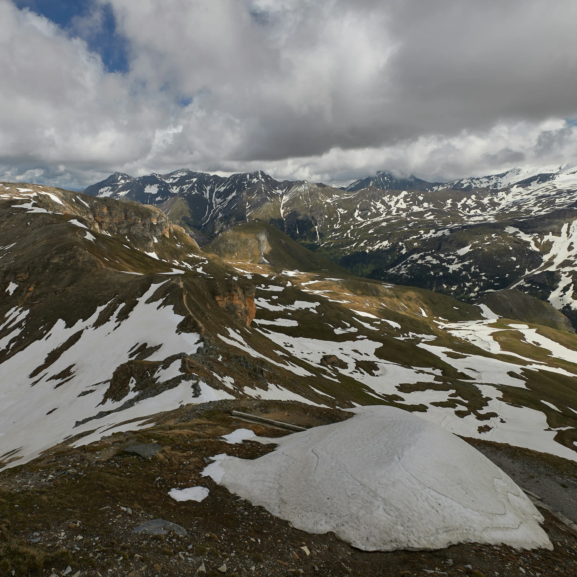 snow capped mountains are in the distance on a cloudy day