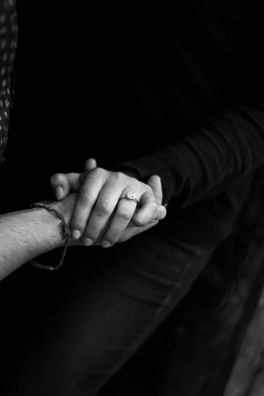 two people hold hands in the dark