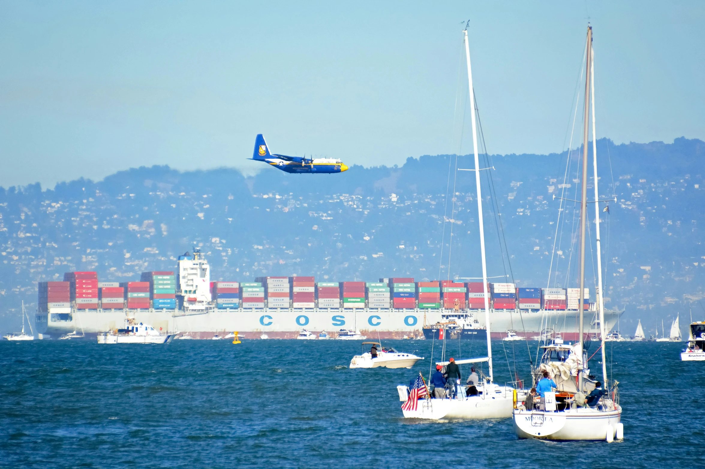 an airplane flies in the sky over boats