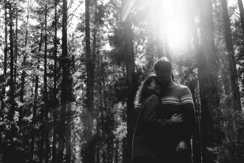 a woman standing in the forest holding her baby