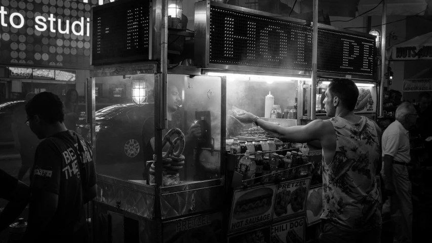 a man standing next to a machine filled with drinks