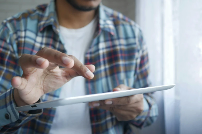 a man holds an electronic device that has soing in his hand