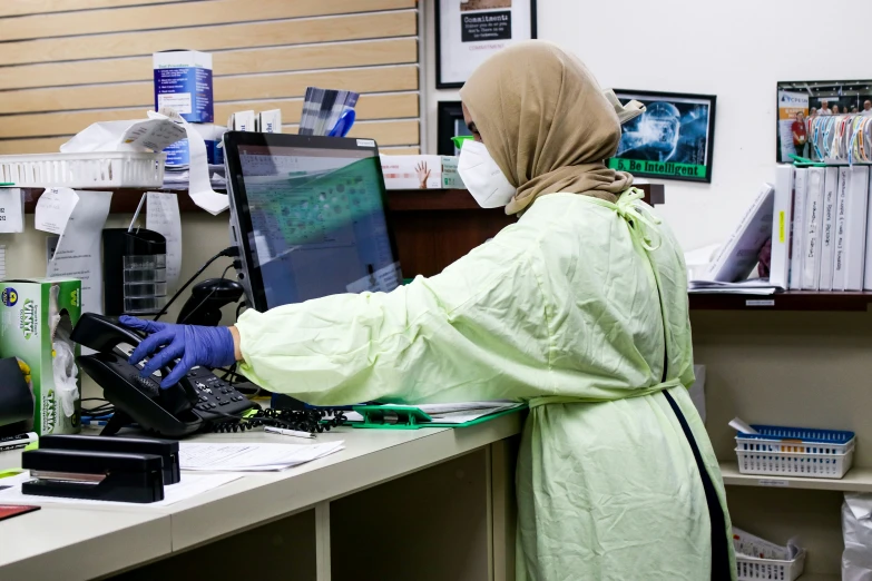 a person in green scrubs working at a desk