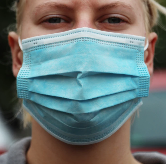 a young woman wearing a blue face mask