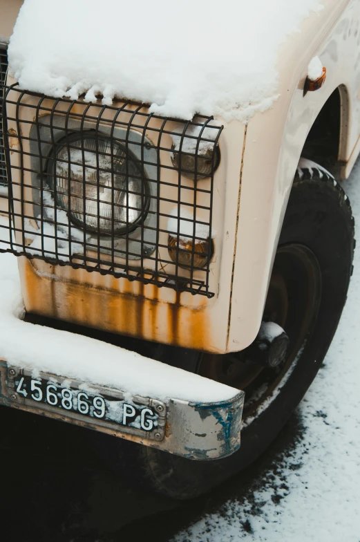 an old truck with snow piled on the tires