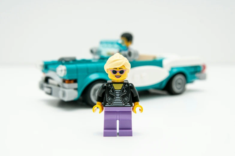 a small lego figure has a car and a man