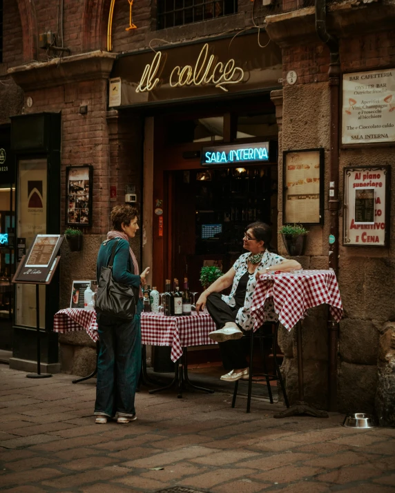 two men are sitting at a table outside