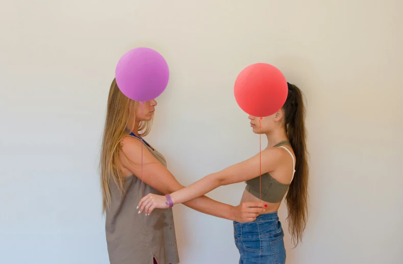 two girls in a room both have their hands on the hips