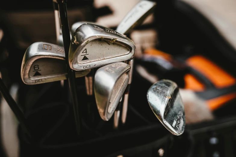 a close - up of a clubs, putter, and irons