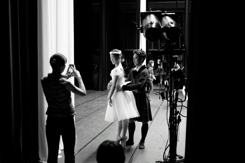 a person taking pictures of two women on the set of her fashion show