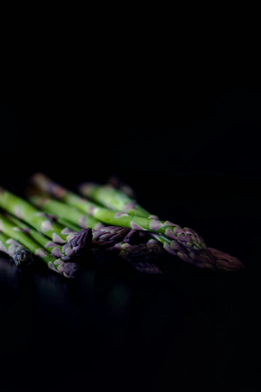 a close up s of asparagus on a dark surface