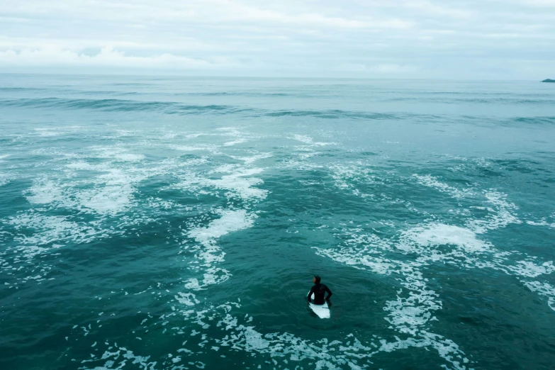 a surfer surfing on the ocean in the middle of the day