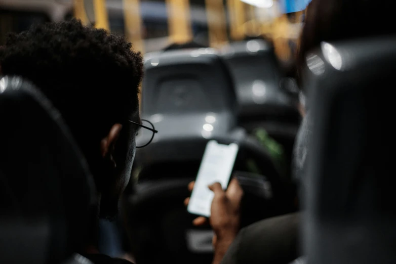 the passenger is sitting down and checking his phone