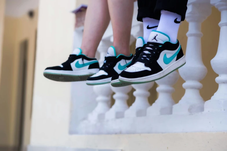 a couple in high top sneakers are hanging out of a set of stairs