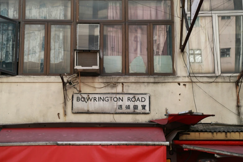 a street sign near a large window and red awning