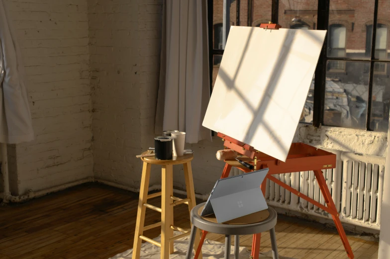 an easel and easel are next to a picture of the outside of a window