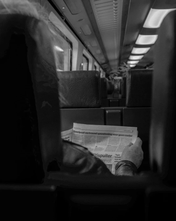 a black and white po of newspaper on a train