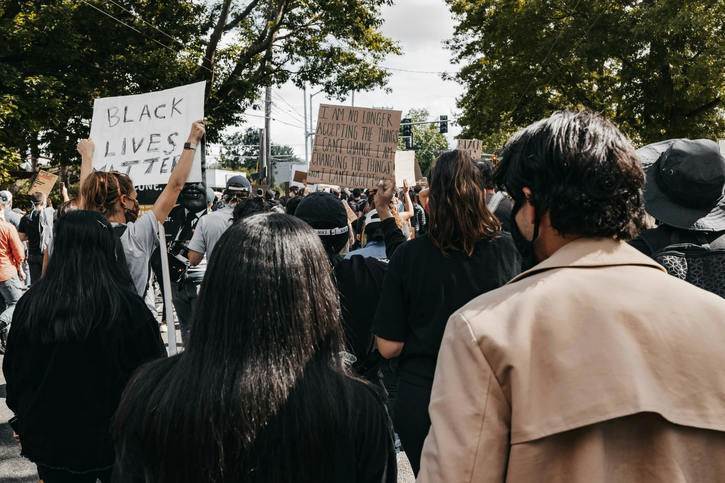 protesters march in protest with placards and signs