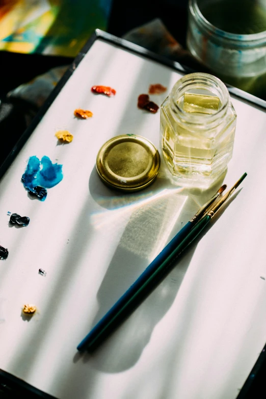 art supplies, with paint and a brush sitting on a tray